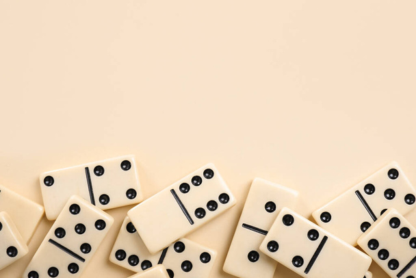 Classic domino tiles on beige background, flat lay. Space for text - 写真・画像