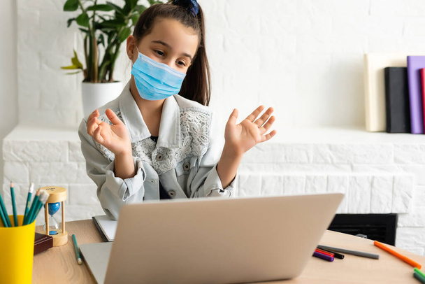 menina em máscara médica estudando em casa. epidemia, pandemia - Foto, Imagem
