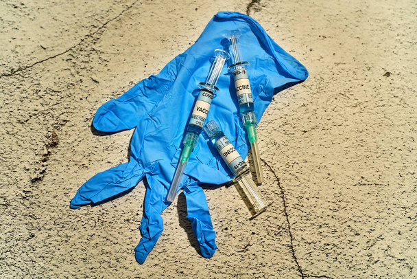visão de perto de três seringas da vacina Covid-19 numa luva de vinil azul com a vacina de rótulo apenas com covid-19 injetável - Foto, Imagem
