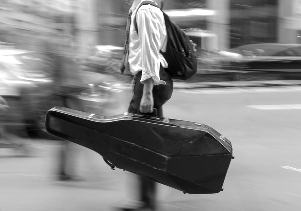 Blurred image of a musician with a case  - Valokuva, kuva