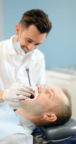 Dentista y paciente durante un tratamiento de ortodoncia - Foto, Imagen