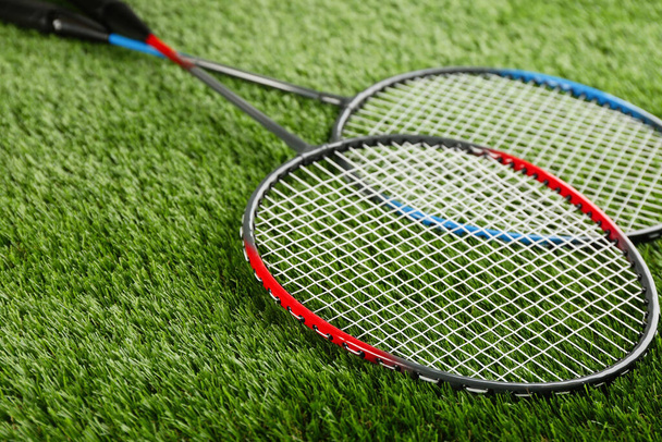 Badminton rackets on green grass outdoors, closeup - Фото, изображение