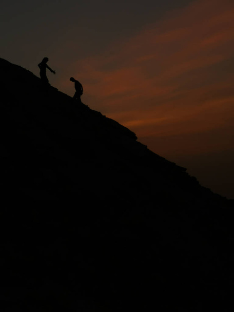 un hombre ayudando a otro hombre a escalar - Foto, Imagen