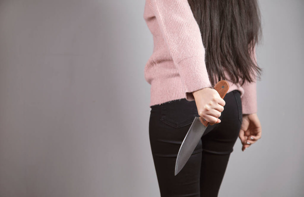 young woman holding knife in back - Fotoğraf, Görsel