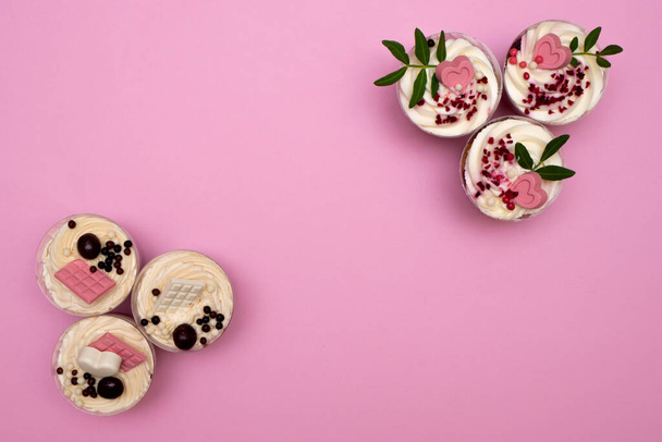 Γλυκό μικρό σπιτικό γλυκό με κρέμα, σοκολάτα, ξηρούς καρπούς και φρούτα και διακοσμήσεις και τυρί κρέμα. Flatly σε ροζ φόντο αντίγραφο χώρου - Φωτογραφία, εικόνα
