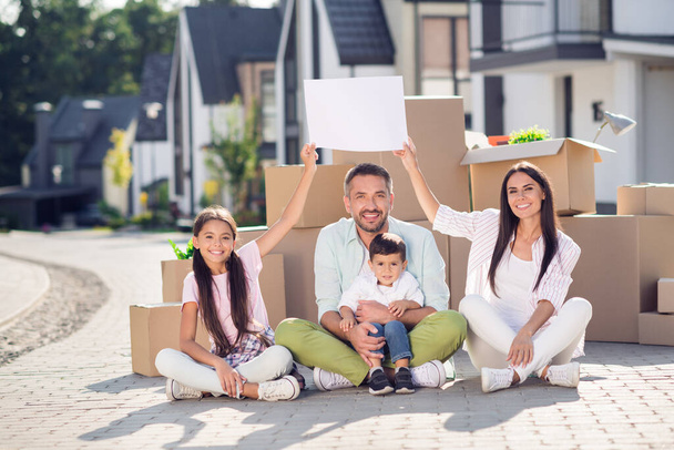 Full size photo of family mommy daddy children sit together near boxes relocation new apartment happy positive smile harmony - Fotoğraf, Görsel
