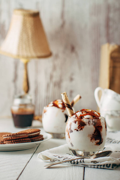 δύο επιδόρπια παγωτό με σοκολάτα σε γυάλινα μπολ. Για teable κουταλάκι του γλυκού ψέμα. - Φωτογραφία, εικόνα