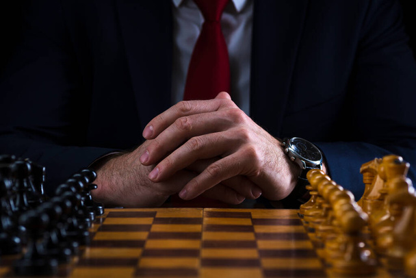 the concept of strategy and business planning, a businessman at a chessboard with figures lined up in their places, strategy and tactics, readiness for battle. - Fotografie, Obrázek