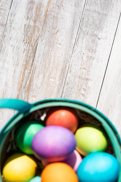 A rainbow of Easter Eggs on a white and weathered wood background. - Foto, afbeelding
