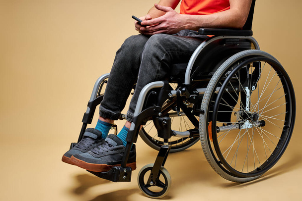 cropped disabled man sitting on wheelchair using smartphone - Фото, зображення