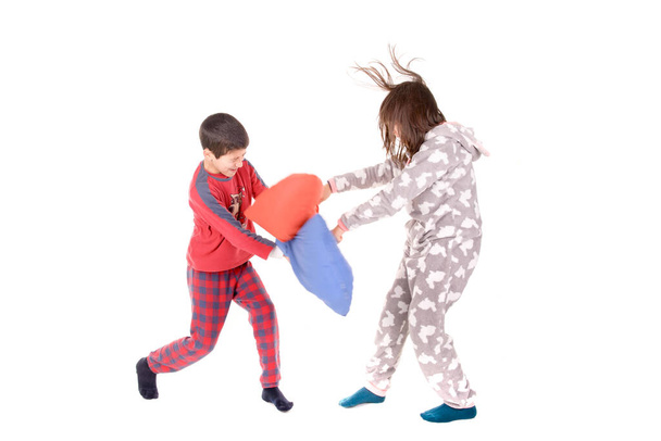 little kids on their pajamas having pillow fights isolated in white - Foto, immagini