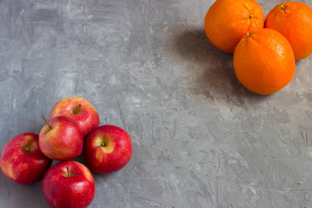 Oranges and apples on a grey concrete background with copyspace - Photo, Image