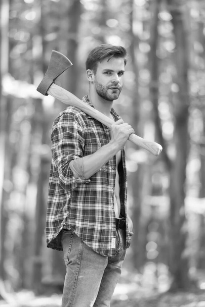 Bearded man in plaid shirt with jeans carry large splitting axe in summer wood natural environment, lumberjack - Φωτογραφία, εικόνα