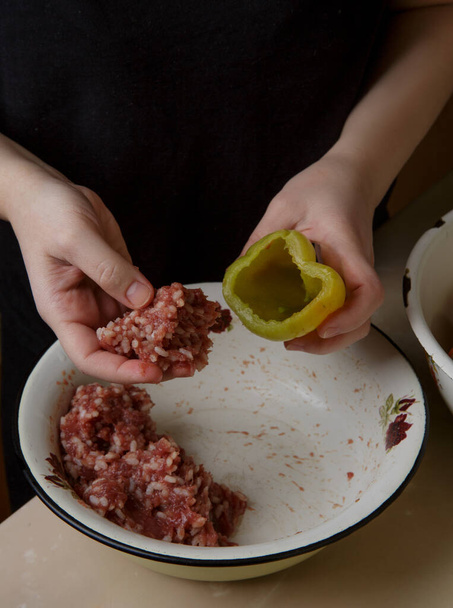 woman hands fills the bell peppers with minced meat - 写真・画像