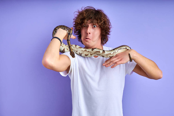 young caucasian man interacting with snake - Foto, afbeelding