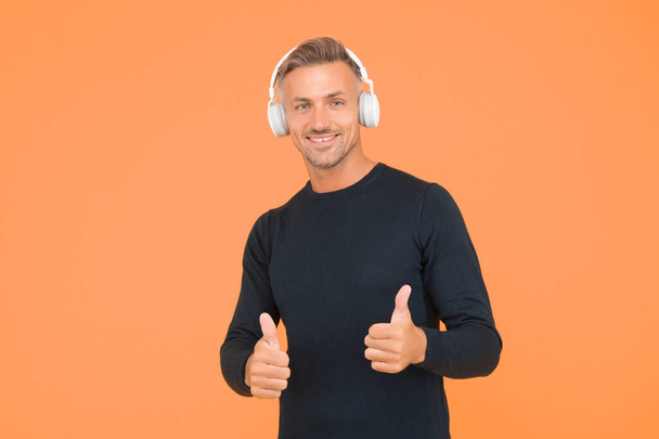 Only the best. music and digital technology. ebook and elearning. unshaven guy in headset listening song. musical app playlist. quality wireless device. happy man wearing earphones show thumb up - Fotó, kép