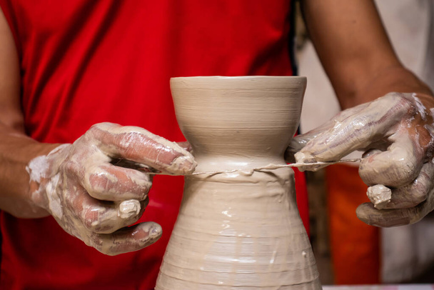 Man making ceramic articles on the potters wheel in a traditional factory in the city of Raquira located in the department of Cundinamarca in Colombia - Photo, Image