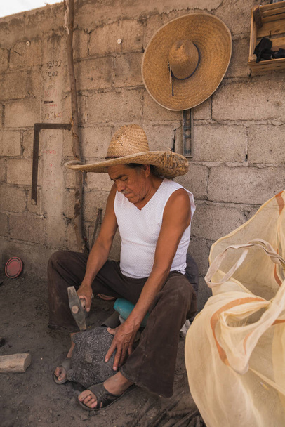 Artisanat travaillant dans son atelier, sculptant la pierre pour faire des molcajetes, artisanat mexicain traditionnel pour moudre des piments, avocat ou tomate pour la préparation de sauces.  - Photo, image
