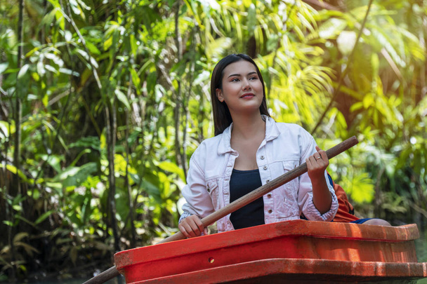 Пригодницька концепція відпочинку та подорожей. Туристи молода жінка носить піджак з дерев'яним човном на помаранчевому човні бачать, як дерево відчуває себе розслабленим на природі
. - Фото, зображення
