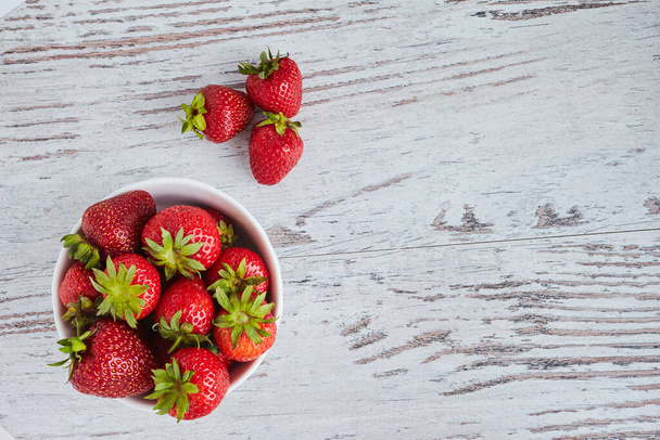 Strawberries in a white bowl - Fotoğraf, Görsel