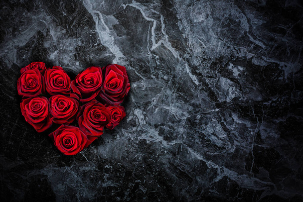 Rosas rojas en forma de corazón sobre fondo de piedra - Foto, imagen