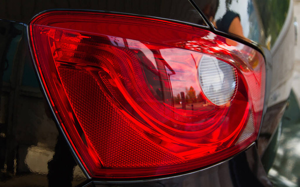 Detalle del faro trasero rojo coche negro con reflejos - Foto, Imagen