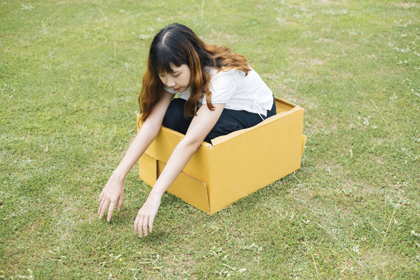 Fiatal ázsiai thai nő hipster göndör frizura fehér ing próbál kijutni a dobozból. Lépj ki a dobozból. Gondolkozz a dobozon.. - Fotó, kép