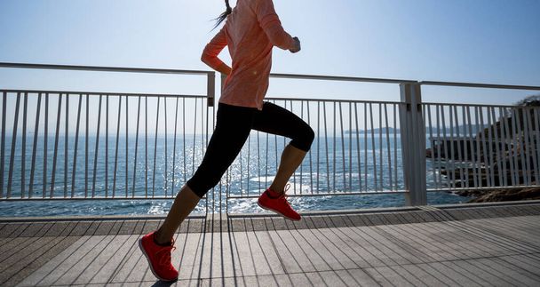 Zdrowy styl życia fitness sport kobieta biegacz działa na nadmorskim szlaku - Zdjęcie, obraz