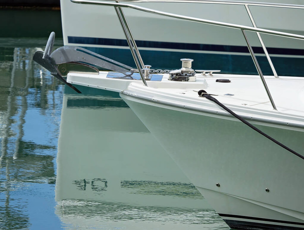 Gros plan de la proue d'un bateau de luxe avec ancre sur le pont et reflets d'eau - Photo, image