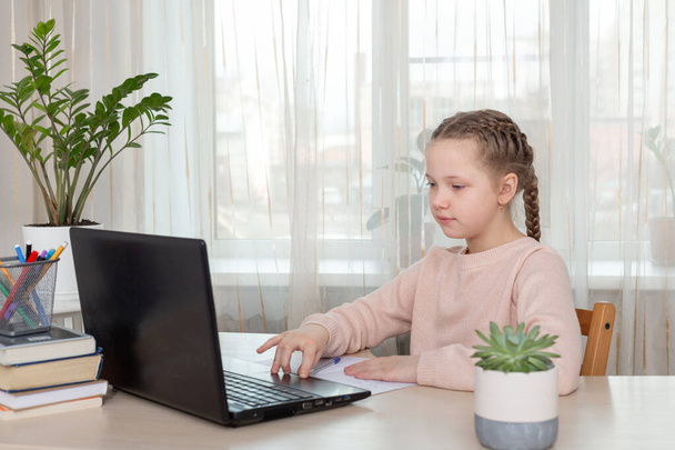 School girl sitting at desk and using laptop. Education at home Back to school - Fotoğraf, Görsel