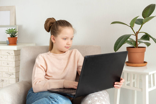 Teenage girl studying at home using laptop. Distance learning, online education, home education, quarantine concept - Photo, Image
