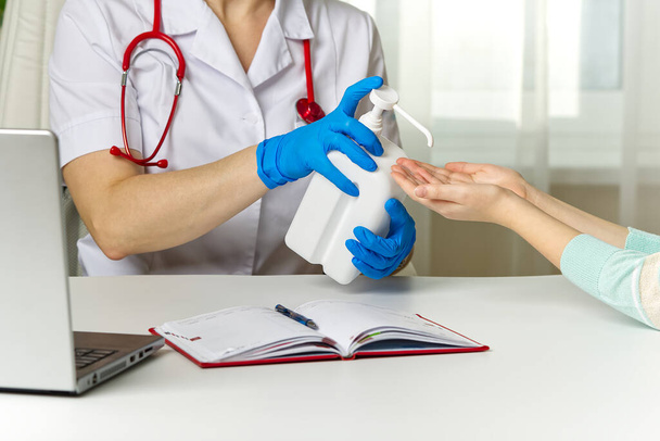 医者は医者に来る患者の手を消毒する - 写真・画像