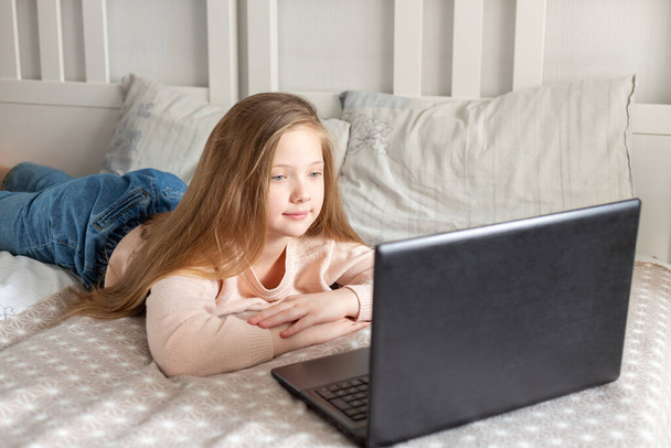 Schoolgirl using laptop computer at home. Distance learning, online education, home education, quarantine concept - Fotografie, Obrázek