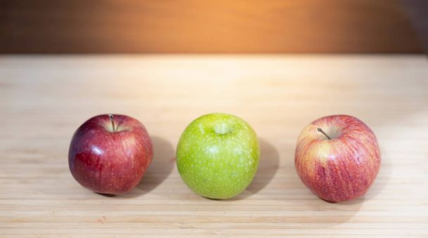 Várias maçãs coloridas na tábua de madeira de corte, Lugar para texto. - Foto, Imagem
