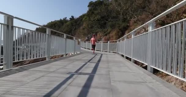 Sports woman running on wooden bridge seaside - Footage, Video