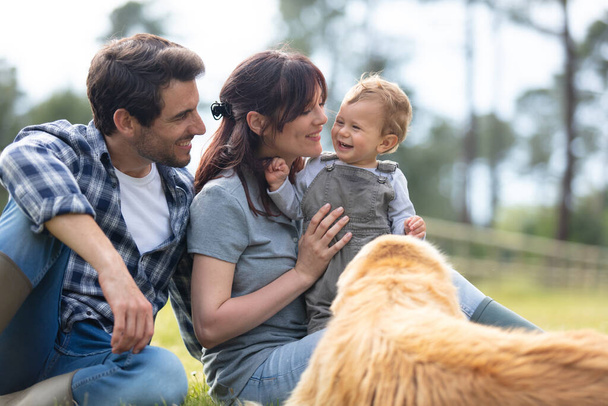 family concept with parents kids and dog in field - Фото, изображение