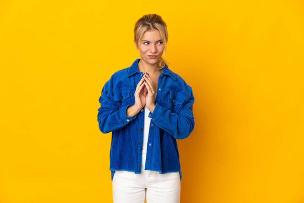 Young Russian woman isolated on yellow background scheming something - Photo, Image