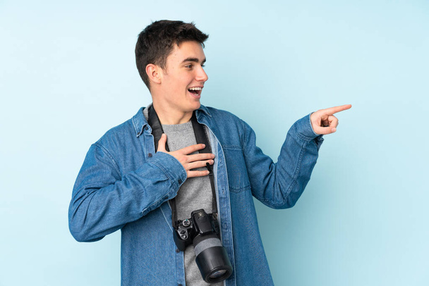 adolescent photographe l'homme isolé sur bleu fond pointant doigt sur l 'côté - Photo, image