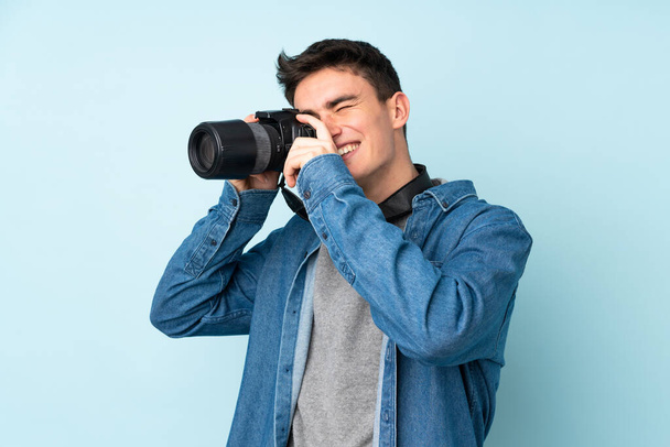 Έφηβος φωτογράφος απομονωμένος σε μπλε φόντο - Φωτογραφία, εικόνα