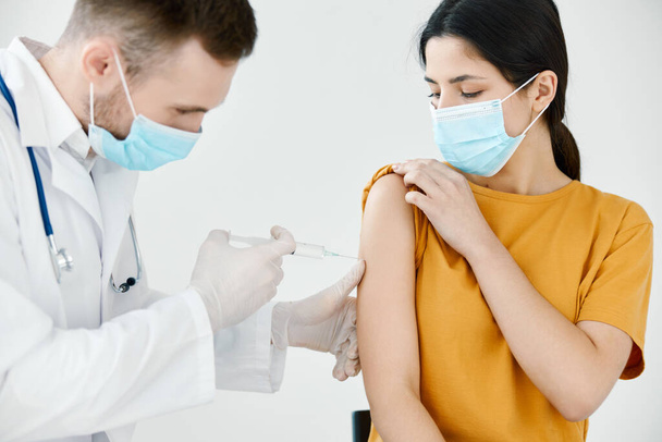 ιατρός με ιατρική μάσκα που κάνει ένεση σε γυναίκα με εμβολιασμό ώμου υγεία - Φωτογραφία, εικόνα