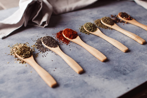 A selective focus shot of assortment of spices: chia, paprika, parsley, rosemary, and teas - Φωτογραφία, εικόνα