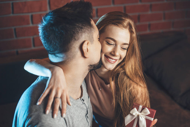 Caucásico pareja besándose después de que el chico le dio a su amante un regalo en día de San Valentín - Foto, Imagen