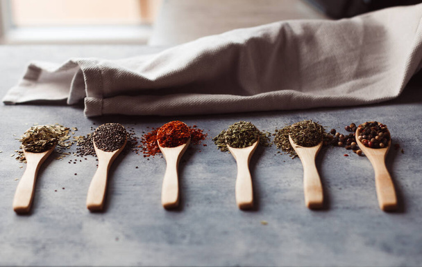 A selective focus shot of assortment of spices: chia, paprika, parsley, rosemary, and teas - Photo, Image