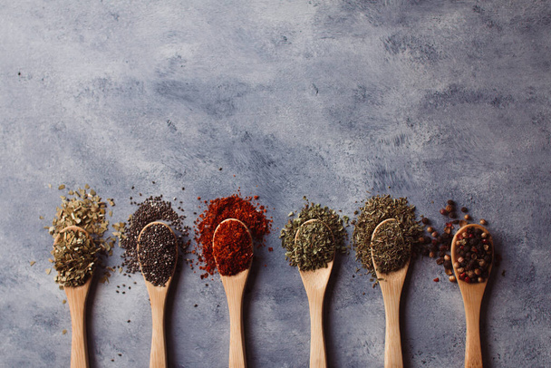 A top view of assortment of spices: chia, paprika, parsley, rosemary, and teas - Φωτογραφία, εικόνα