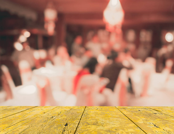 Imagen borrosa abstracta de Conjunto de mesa de comedor grande para bodas, cenas o eventos de festivales con hermosa decoración de luces dentro de un gran salón para uso de fondo. (tono vintage) - Foto, Imagen