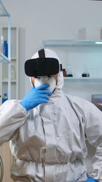 Investigador científico en traje de protección usando VR - Foto, Imagen