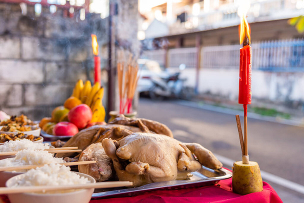 鶏、鴨、チャーハン、米、茶、果物、中国の新年の様々なデザートで構成される中国の信念を崇拝神のためのテーブルの上の食品. - 写真・画像