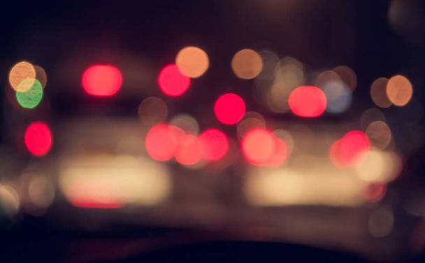 バックグラウンド使用のための夜の時間帯に車を運転する人々のヴィンテージトーンブラーイメージ。(中から写真を撮って) - 写真・画像
