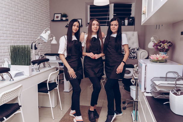 Portrait of happy professional manicurists at workplace inviting to salon. Professional manicurist in special uniform at his workplace in a beauty salon - Photo, Image