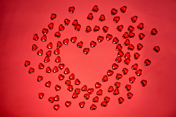 Walentynki tło serca. Wiele kolorowych serc - walentynkowe tło. Piękne dekoracyjne serce ukształtowane na czerwonym tle, koncepcja Walentynki - Zdjęcie, obraz
